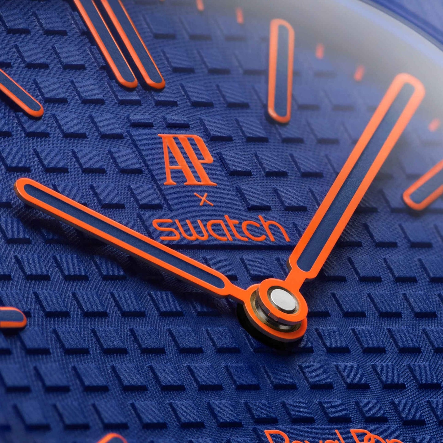 Close-up of inkspireluxury Audemars Piguet x Swatch pocket watch with blue textured dial and vibrant orange accents.